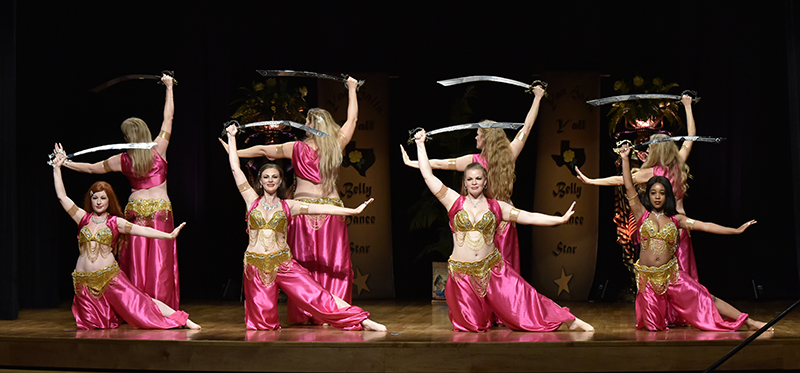 raksettes performers wearing pink and posing with swords on stage